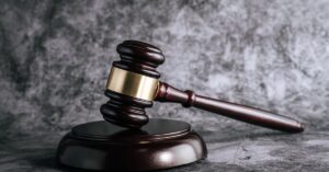 wooden judges gavel on table in a courtroom or enforcement office.