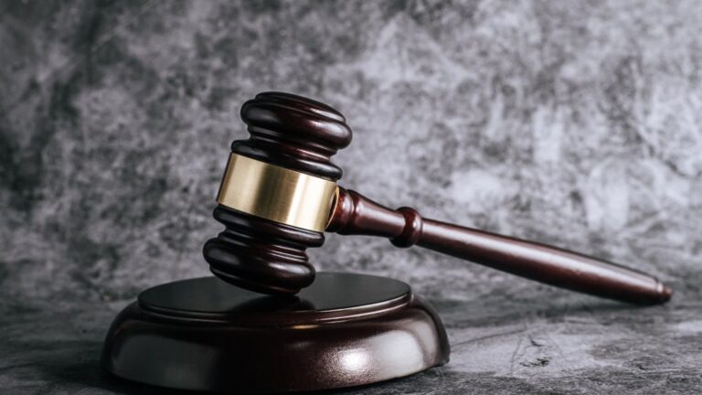 wooden judges gavel on table in a courtroom or enforcement office.